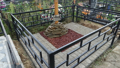 Брусчатка прекрасно сочетается и с металлической оградой и с деревянным крестом